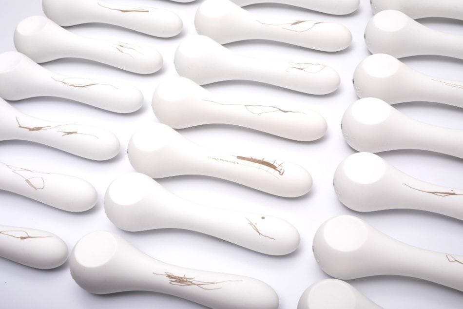 Pohled shora na uspořádané řady bílých designových vibrátorů Whoop-de-doo z limitované edice Musa, přičemž každý produkt nese unikátní jemnou kresbu od umělce Lukáše Musila.