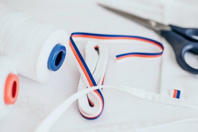 Detailní pohled na trikoloru, nůžky a nitě při výrobě