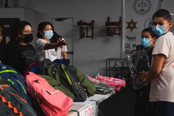 A photo of students receiving free school supplies