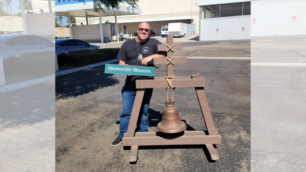 A picture of Detective Ron Knoffloch standing beside the raincross bell