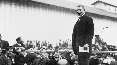 Black and white photo of Dr. Booker T. Washington delivering a speech.
