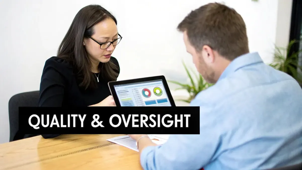 Two professionals collaborating, a woman showing data analysis on a tablet to a man at a table.