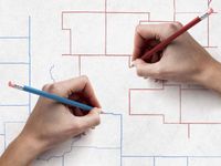 Hands drawing new congressional districts with blue and red pencils