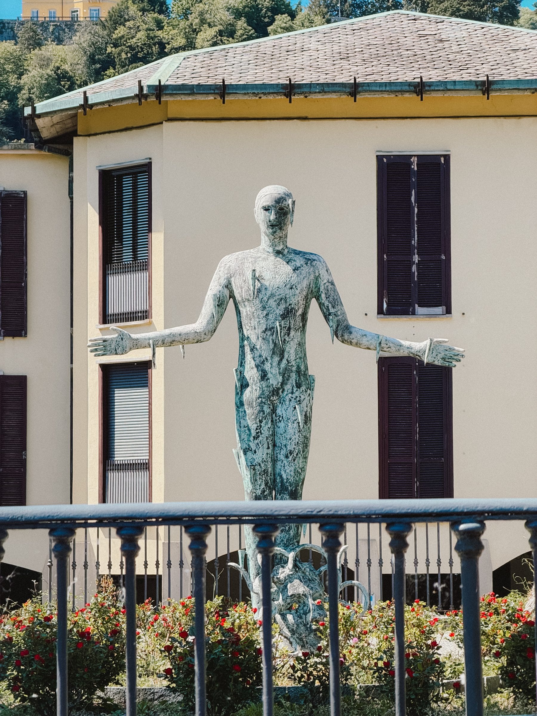 A bronze figure before a villa
