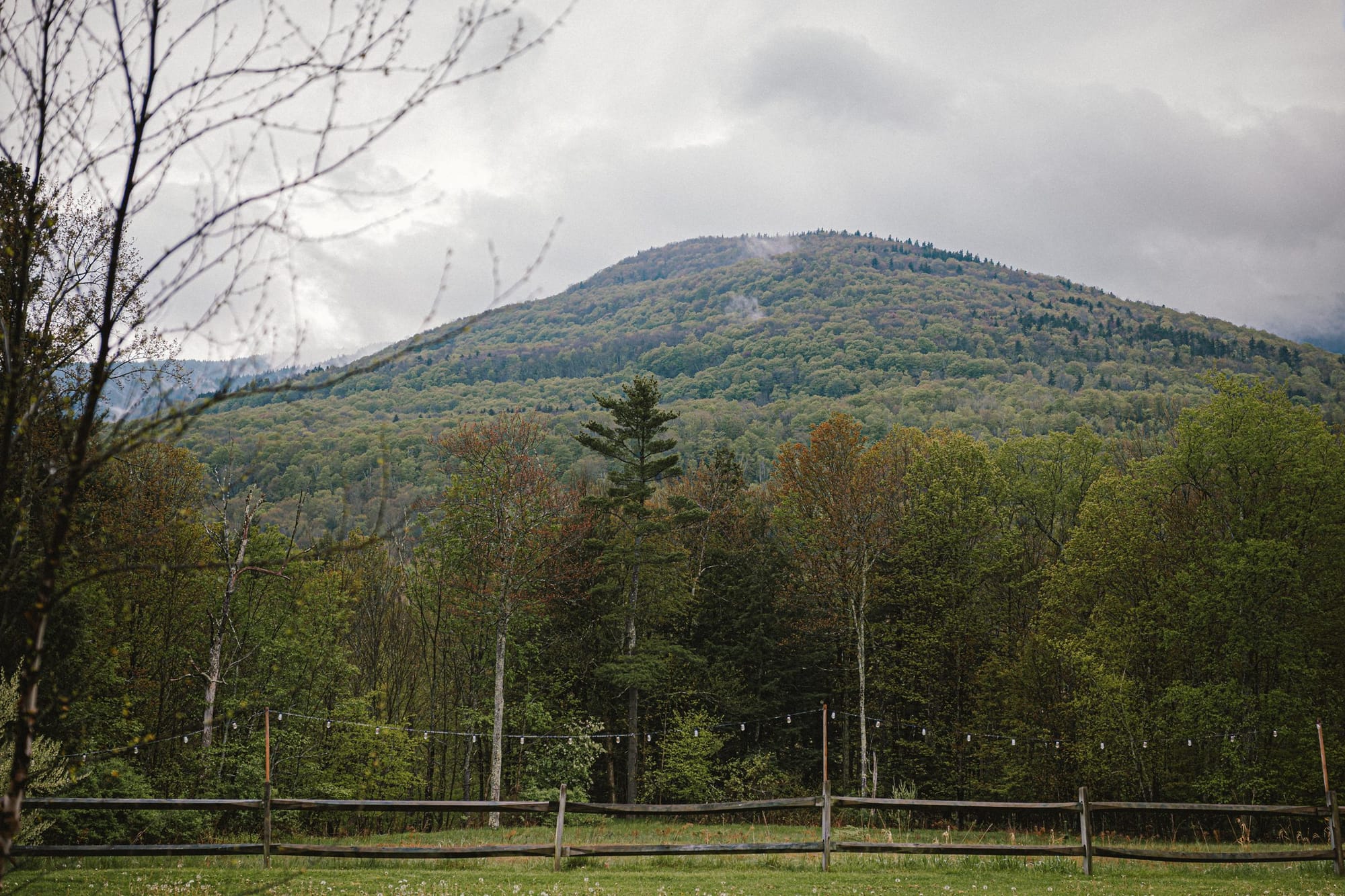 A mountain above a fenced field