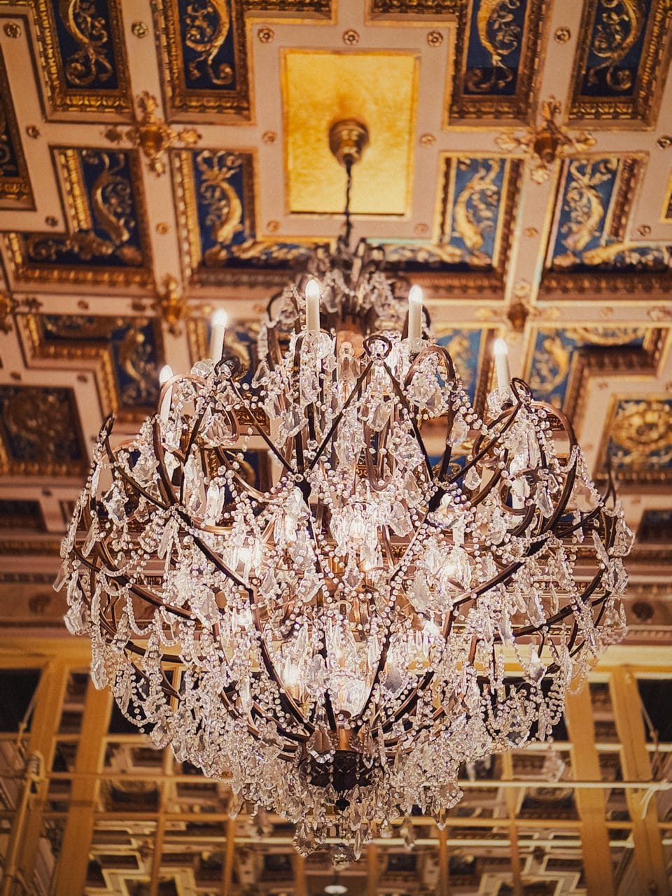 A chandelier under a coffered ceiling