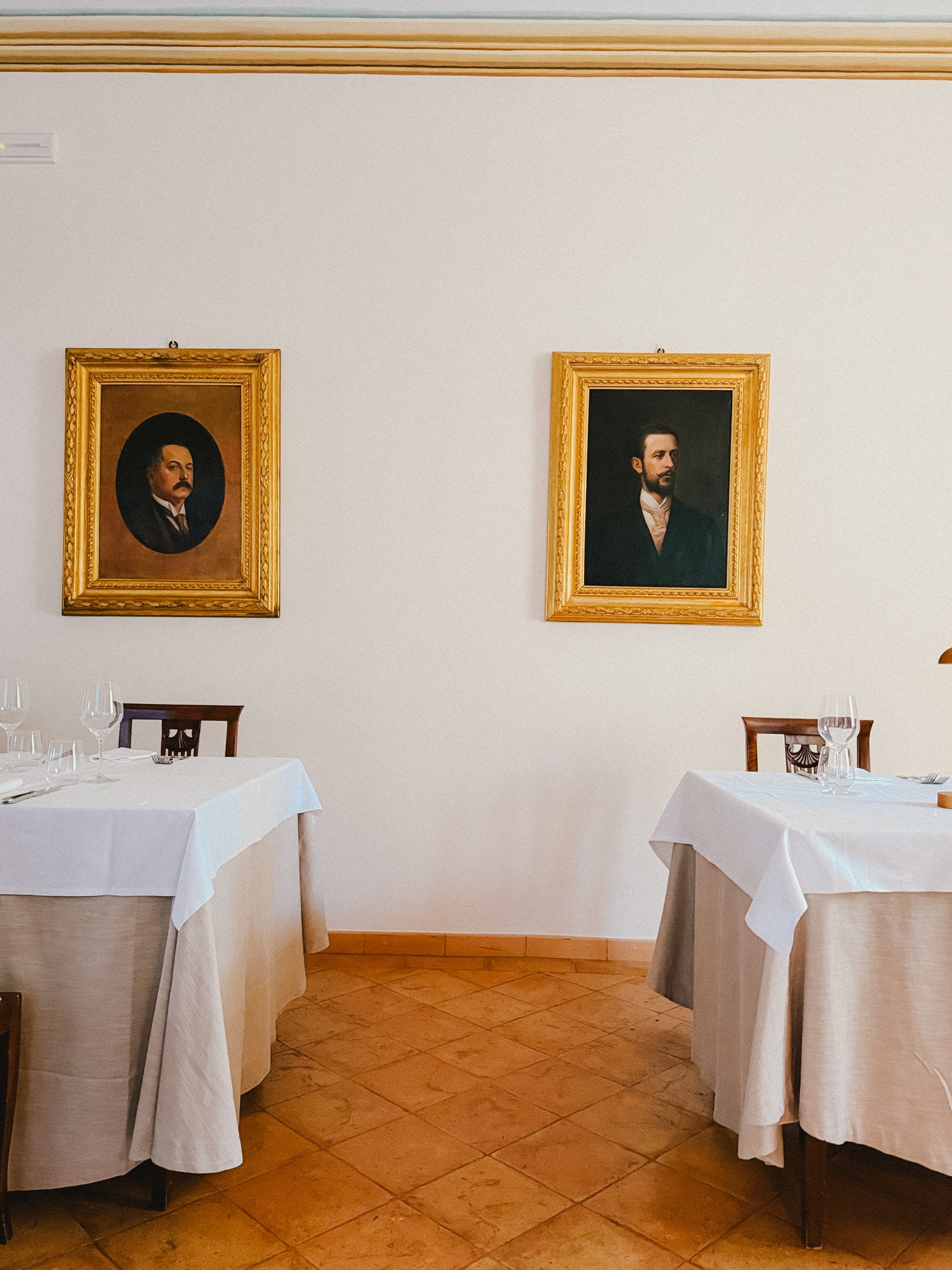 A dining room with two portraits
