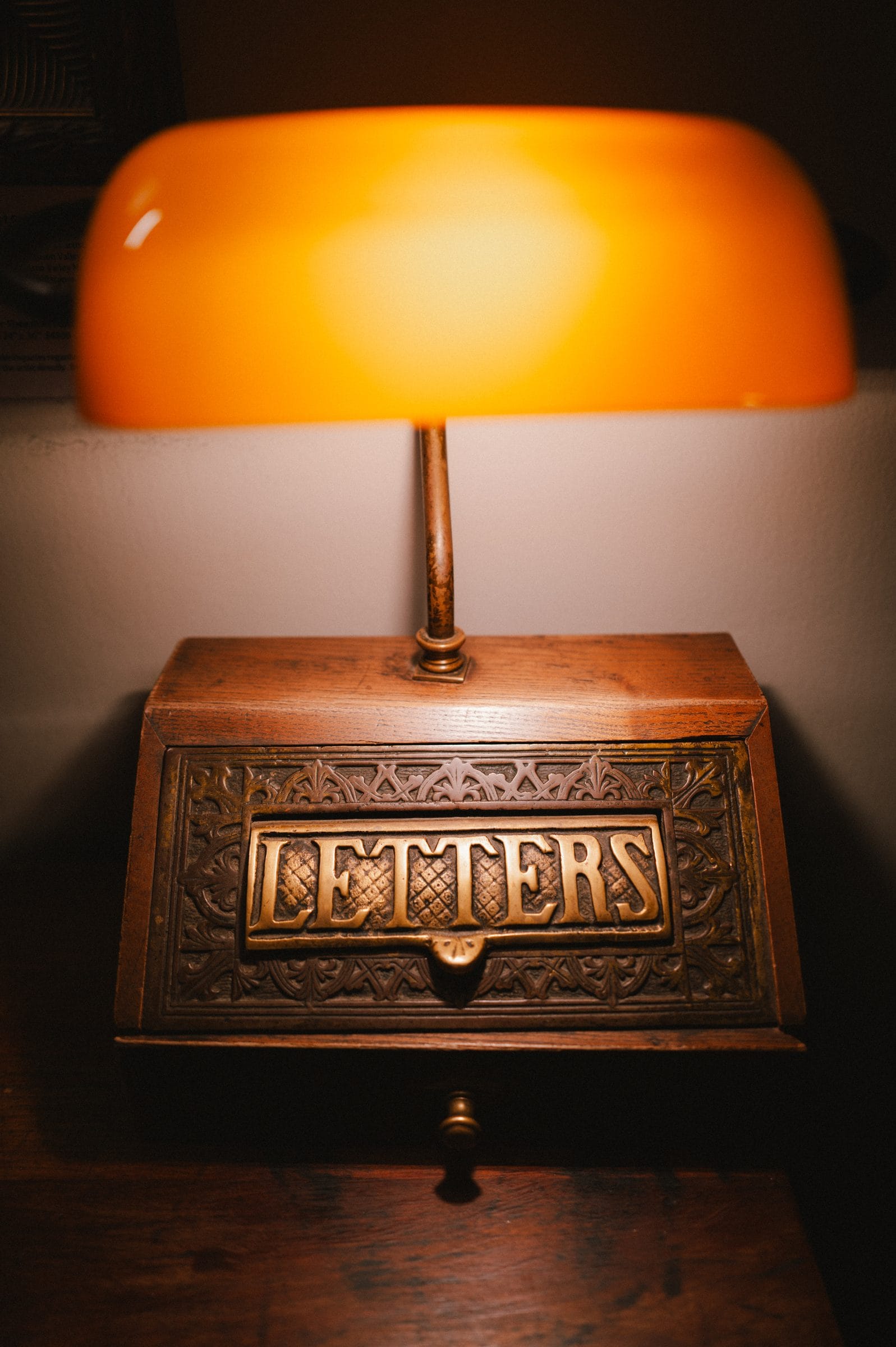 A brass letter box under a lamp