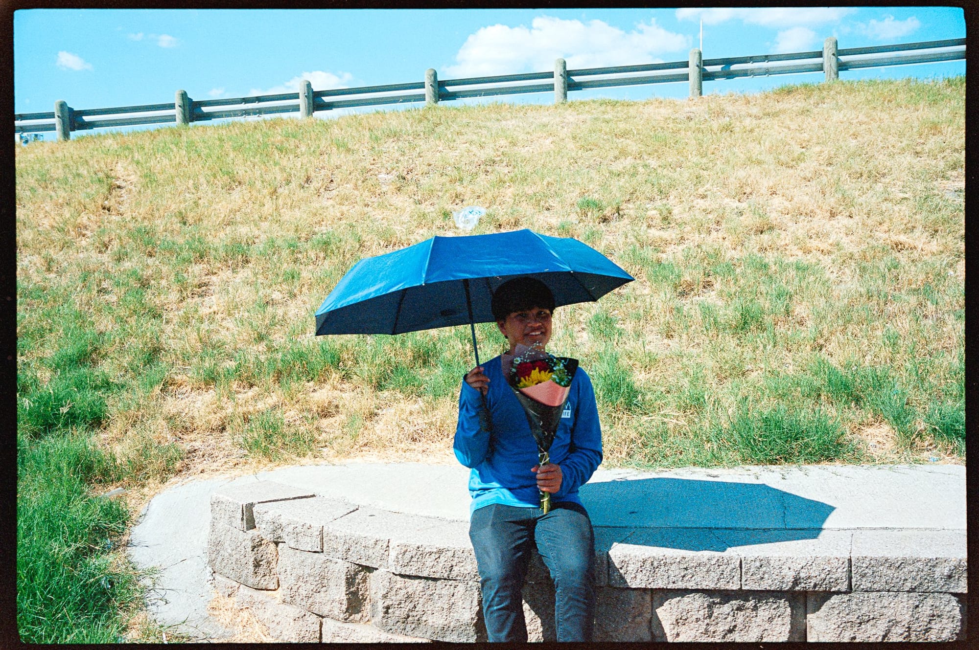 Under an umbrella at the side of the road.