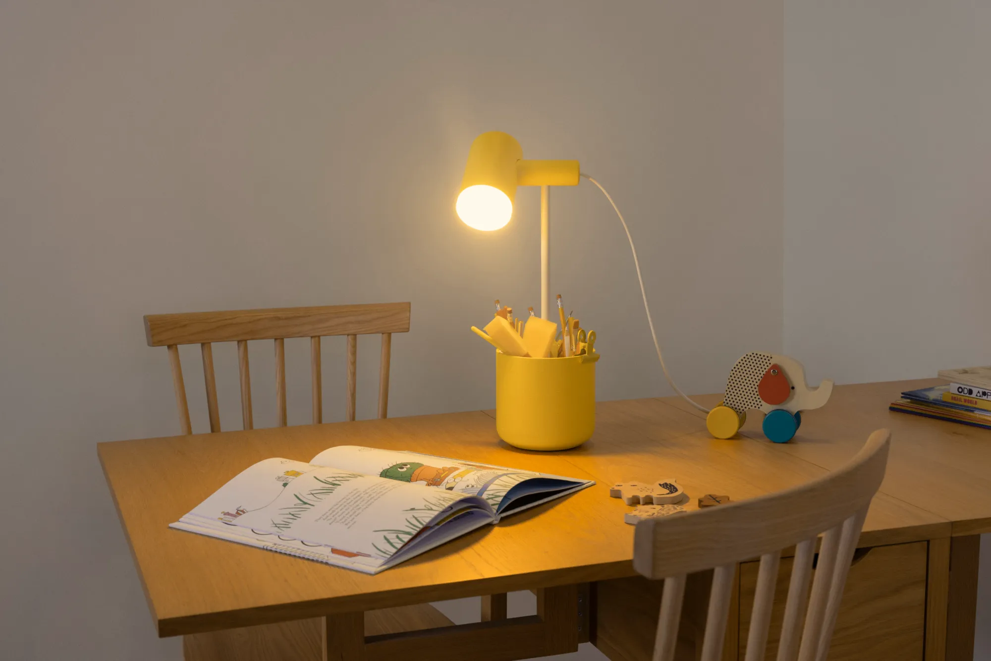 Gantri’s Field Trip Table Light illuminates a large wooden table and chair set
