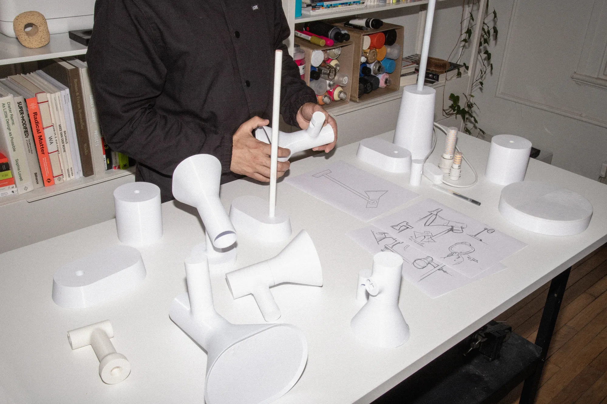 A behind-the-scene photo in the Gantri factory wherein a man is pictured with various Gantri lights in the production stage
