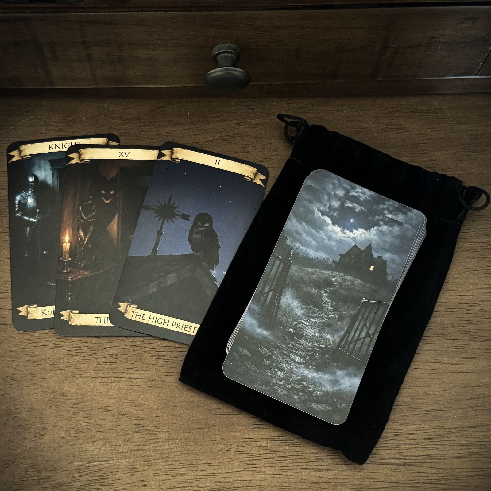 The Haunted House Tarot deck on its black velvet bag, with three cards fanned beside it