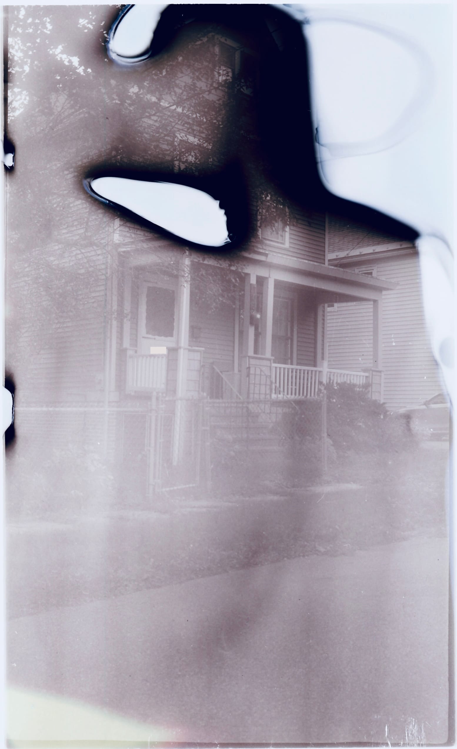 A film scan photo of the front of the house, with holes in the film grain