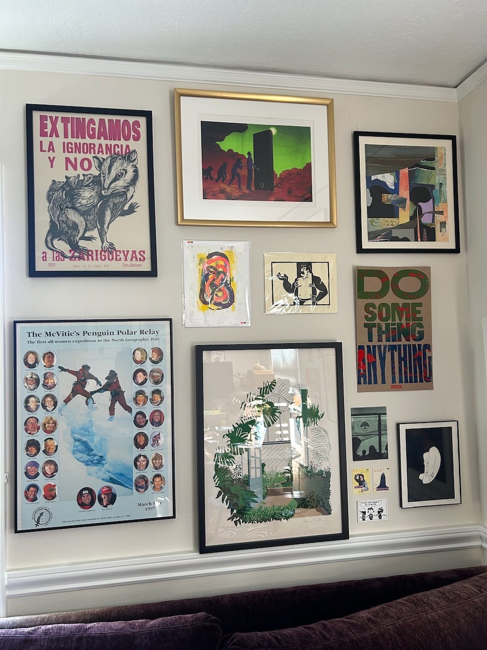 a gallery wall of pictures which features several posters, colorful art, and some graphic prints