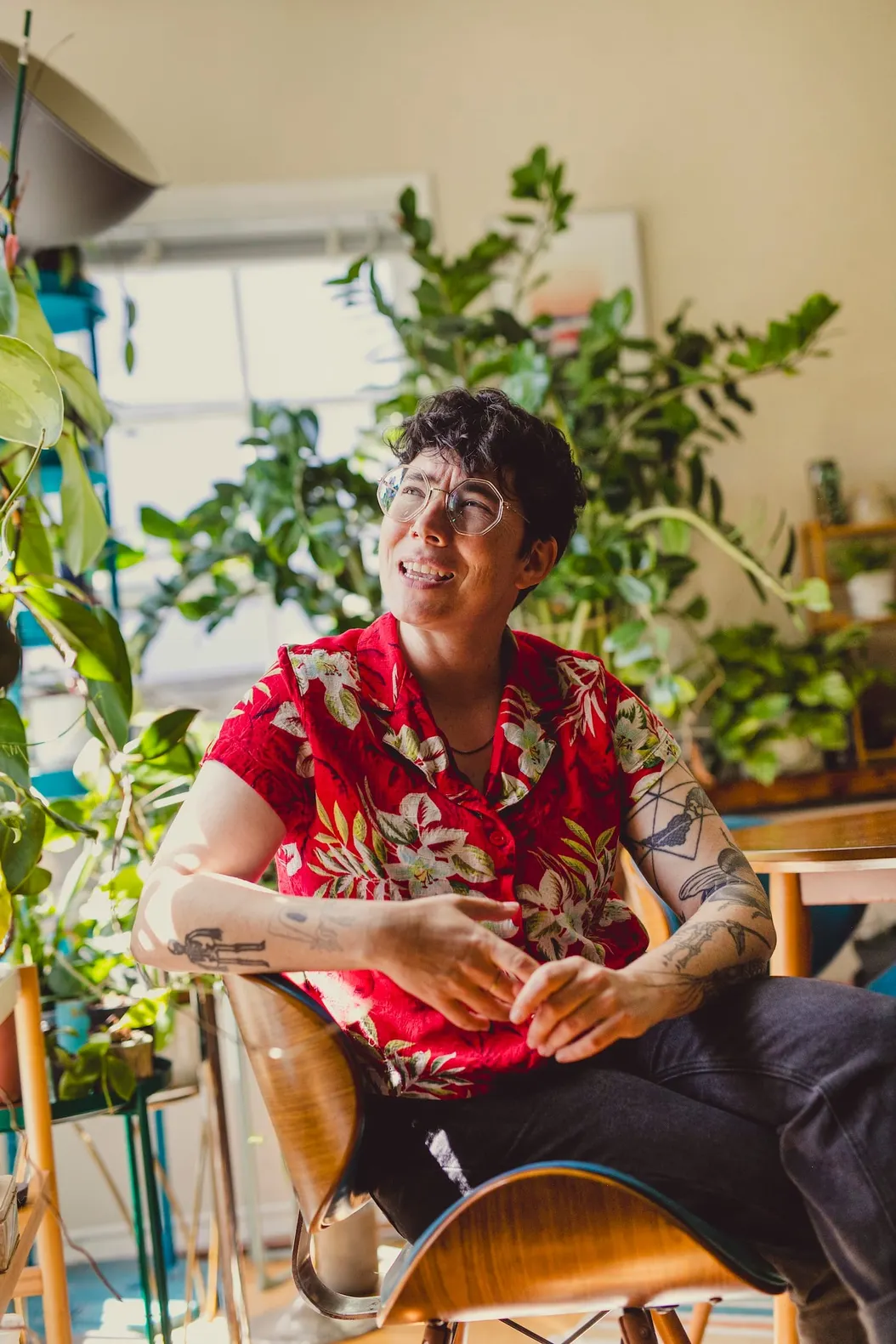 A person (me) wearing a red hawaiian shirt and sitting in front a bunch of plants.