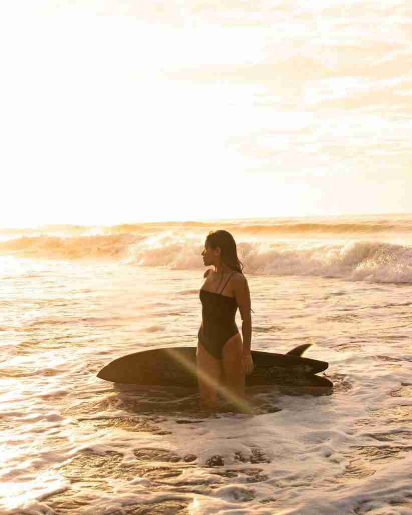 Katherine Diaz stood in the wave with beautiful sunset photo.