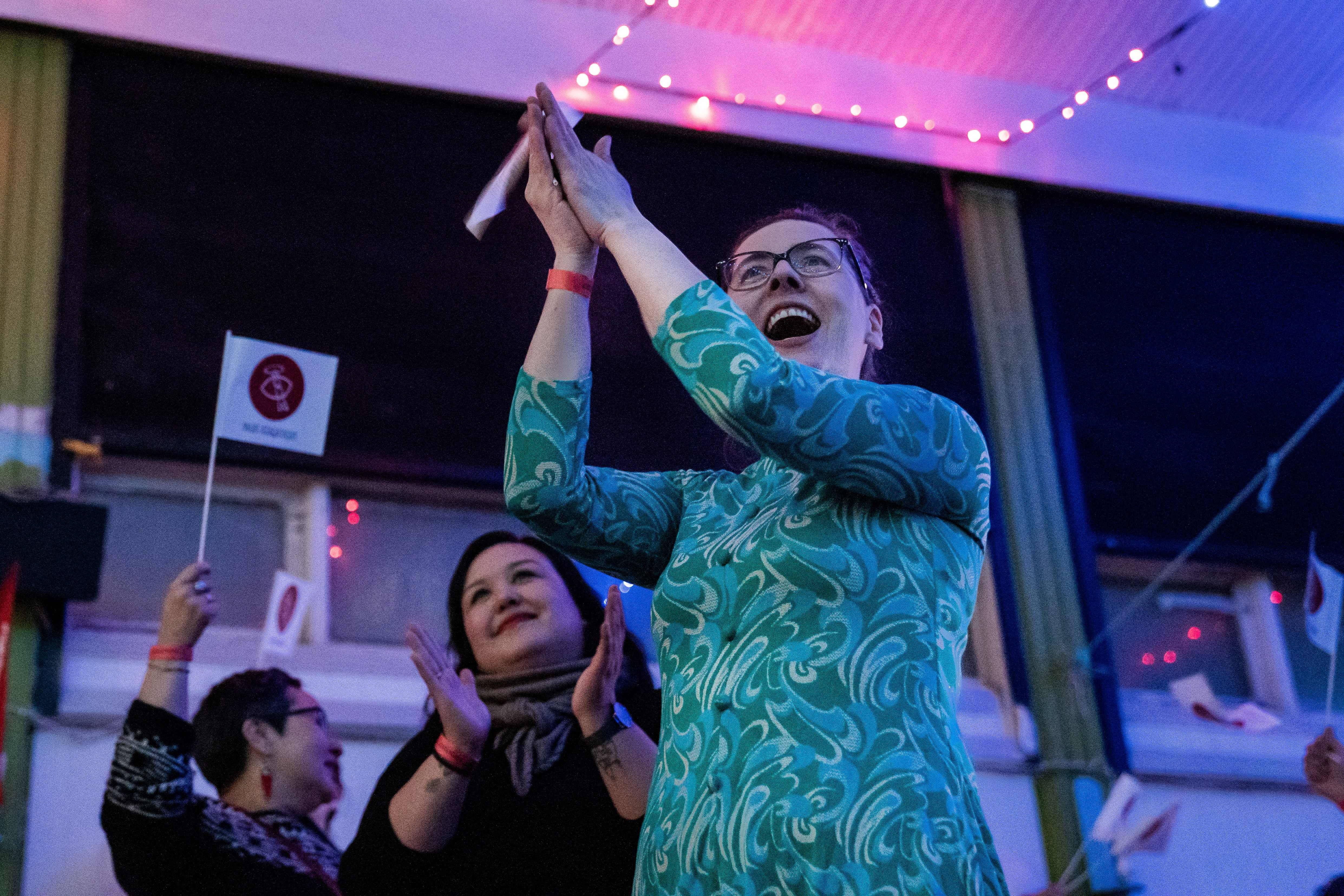 Members of the IA (Inuit Ataqatigiit) party wave party flags as they celebrate following the exit polls results of the legislative election in Nuuk photo.