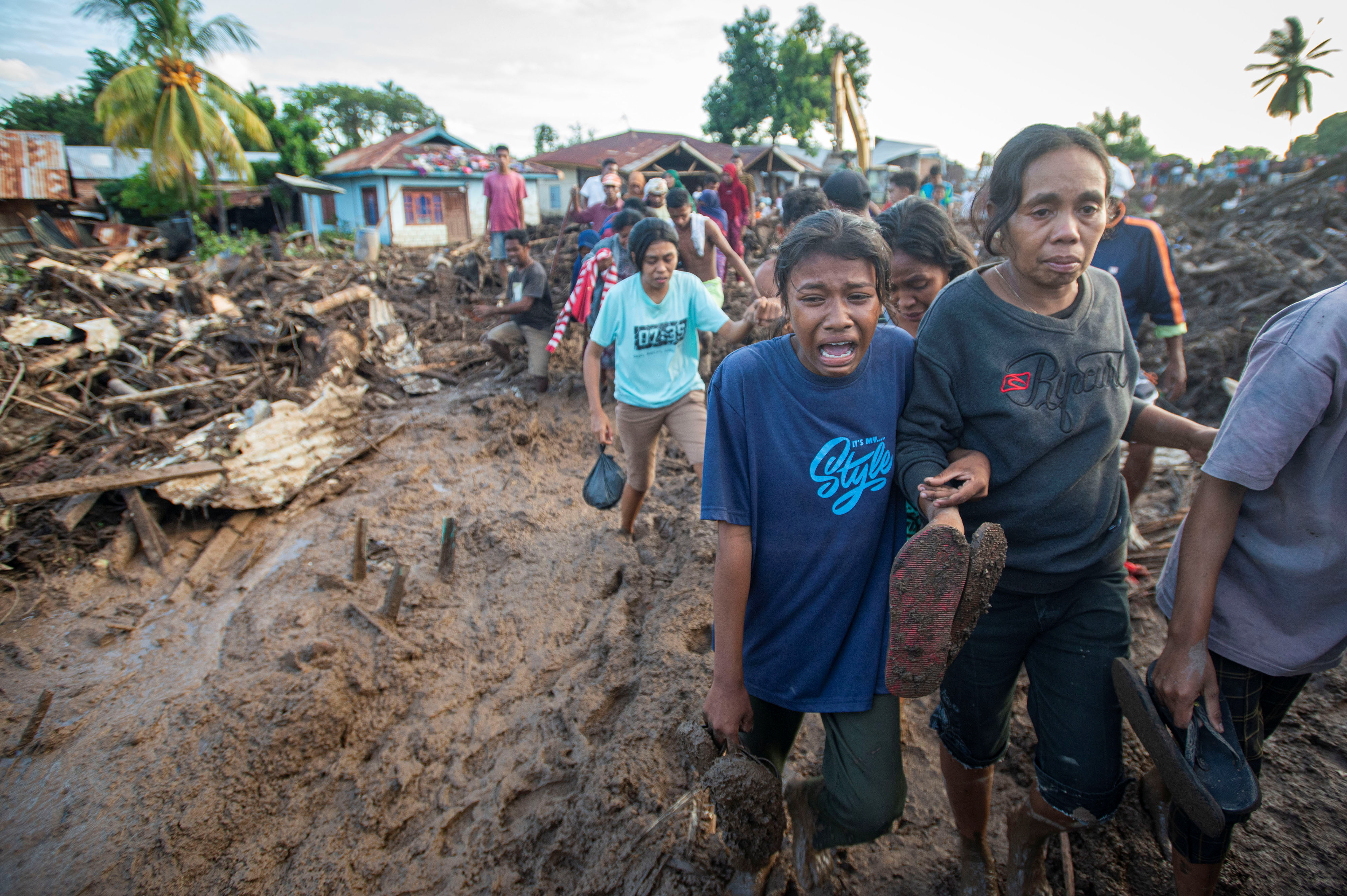 A woman cries over her relative who was found dead in after heavy rain brought flash floods in East Flores, East Nusa Tenggara province, Indonesi photo.