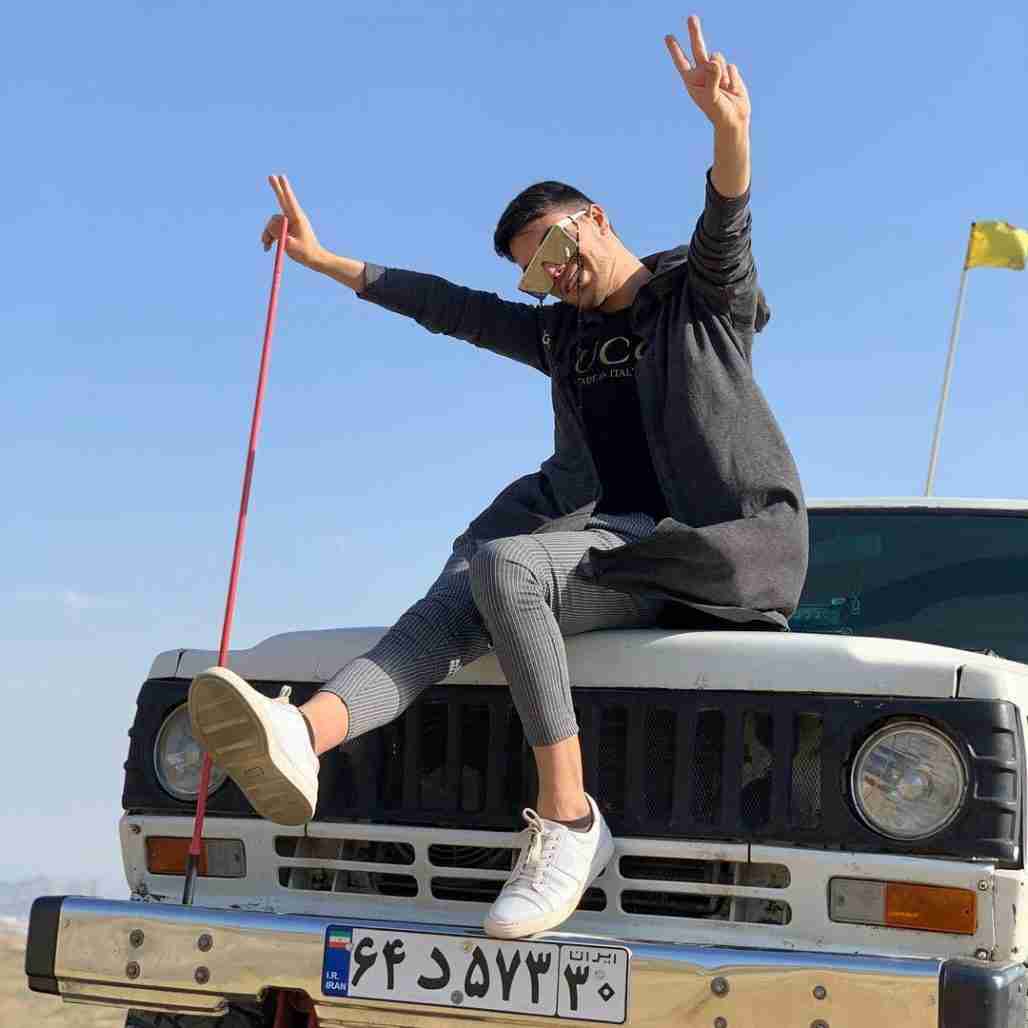 Alireza  Fazeli Monfared sits on the car.