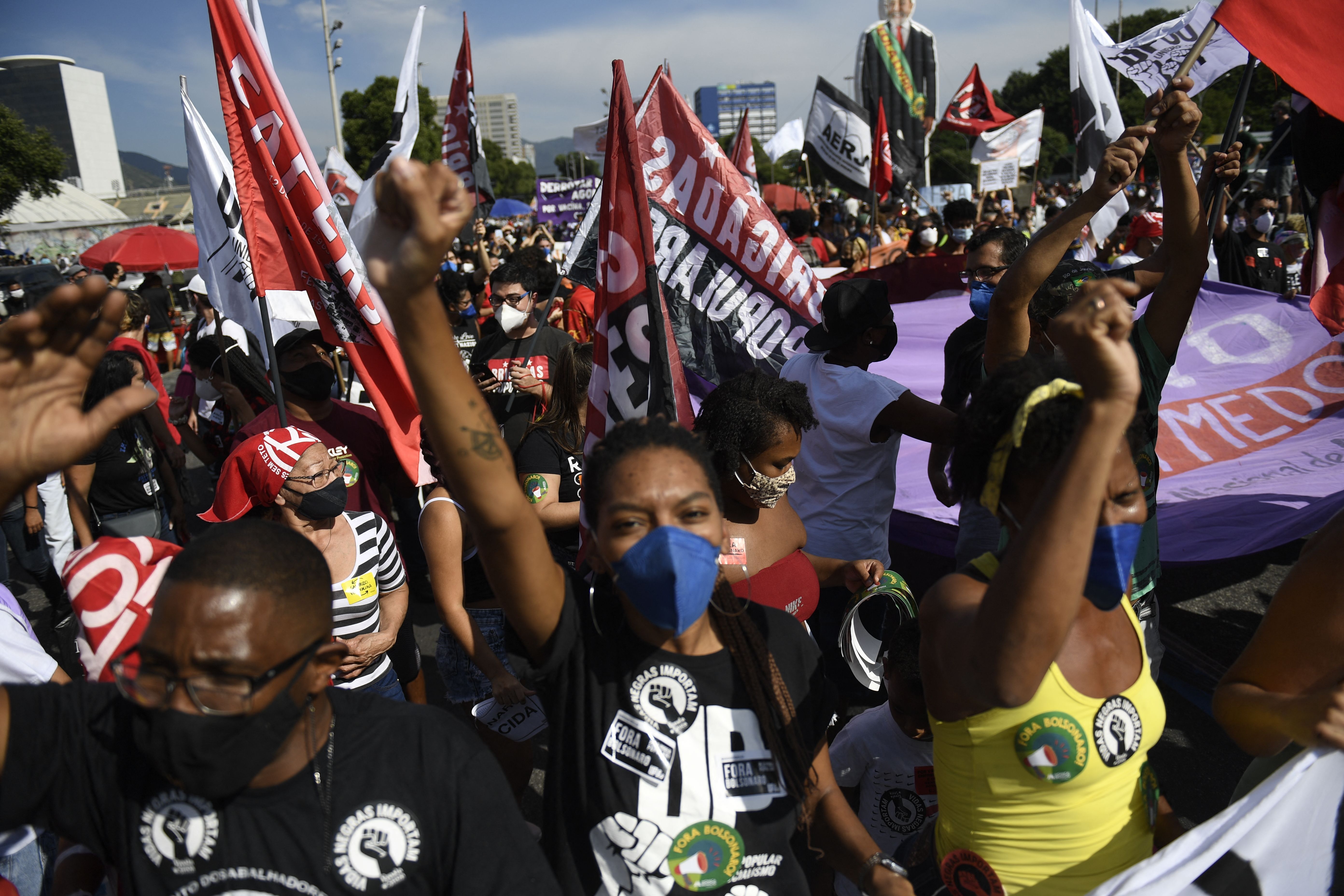 People raise their clenched fists as they shout slogans during a protest against Brazilian President Jair Bolsonaro's handling of the COVID-19 pandemic in downtown Rio de Janeiro, Brazil.