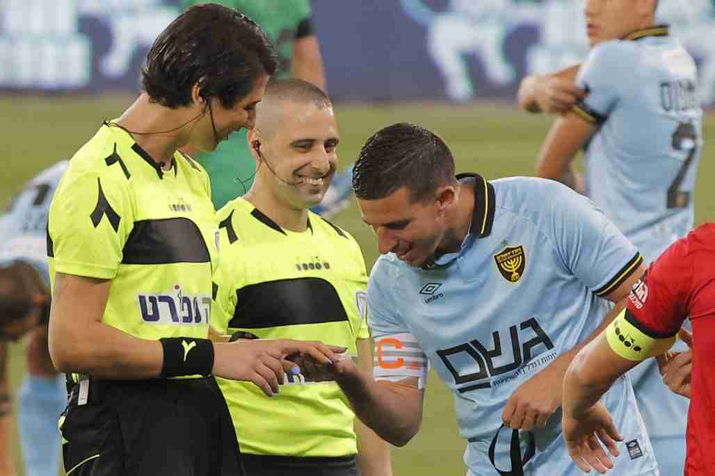 Beitar Jerusalem's captain and midfielder Idan Vered (C-R) inspects the manicured fingers of Israeli football referee Sapir Berman (C-L) before the start of the Israeli Premier League match between Hapoel Haifa and Beitar Jerusalem at Samy Ofer Stadium in Israel's northern Mediterranean coastal city of Haifa.