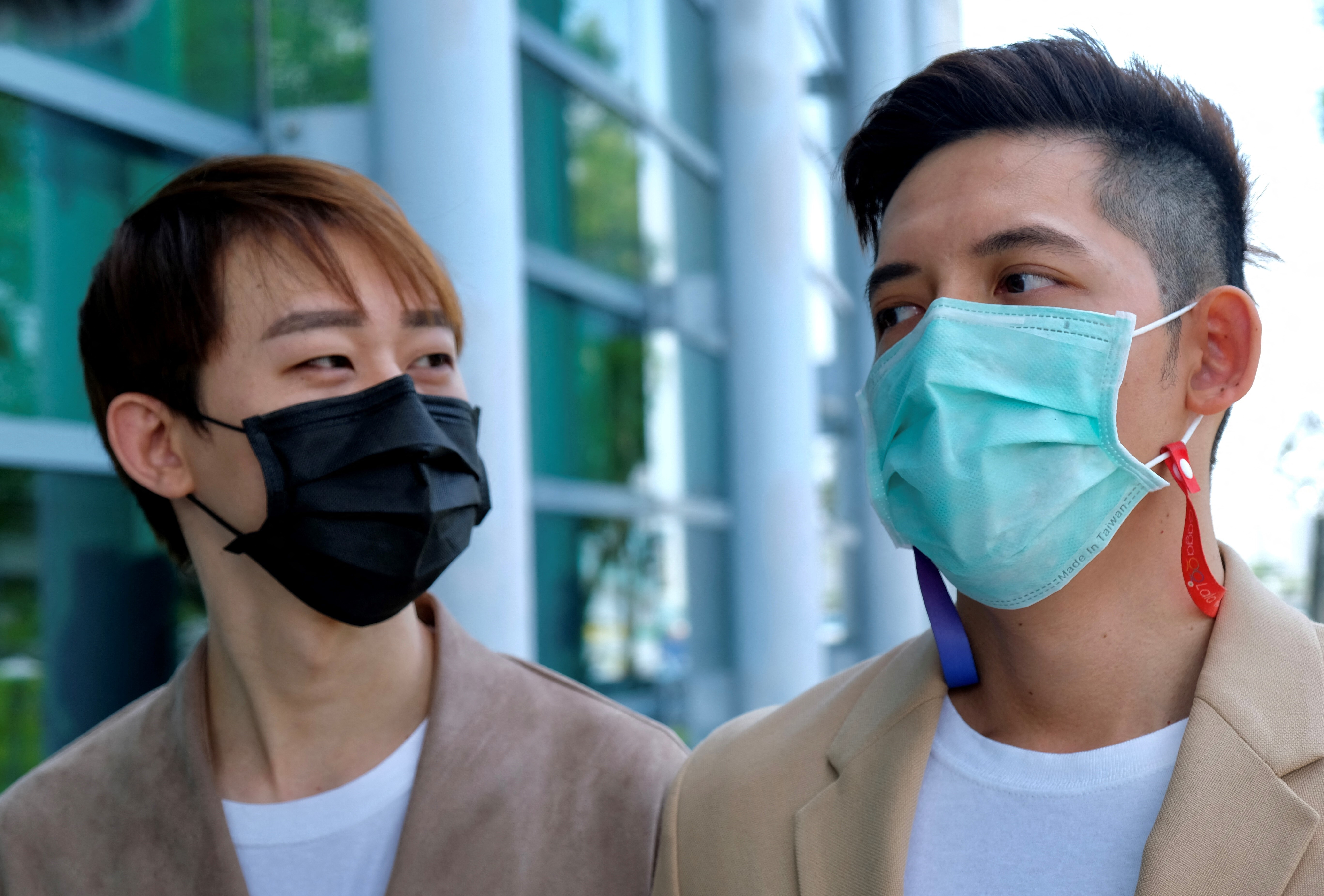 Taiwanese Ting Tse-yen (L) and his Macau same sex partner Leong Chin-fai (R) speak to press in front of Taipei High Administrative Court after winning the lawsuit.