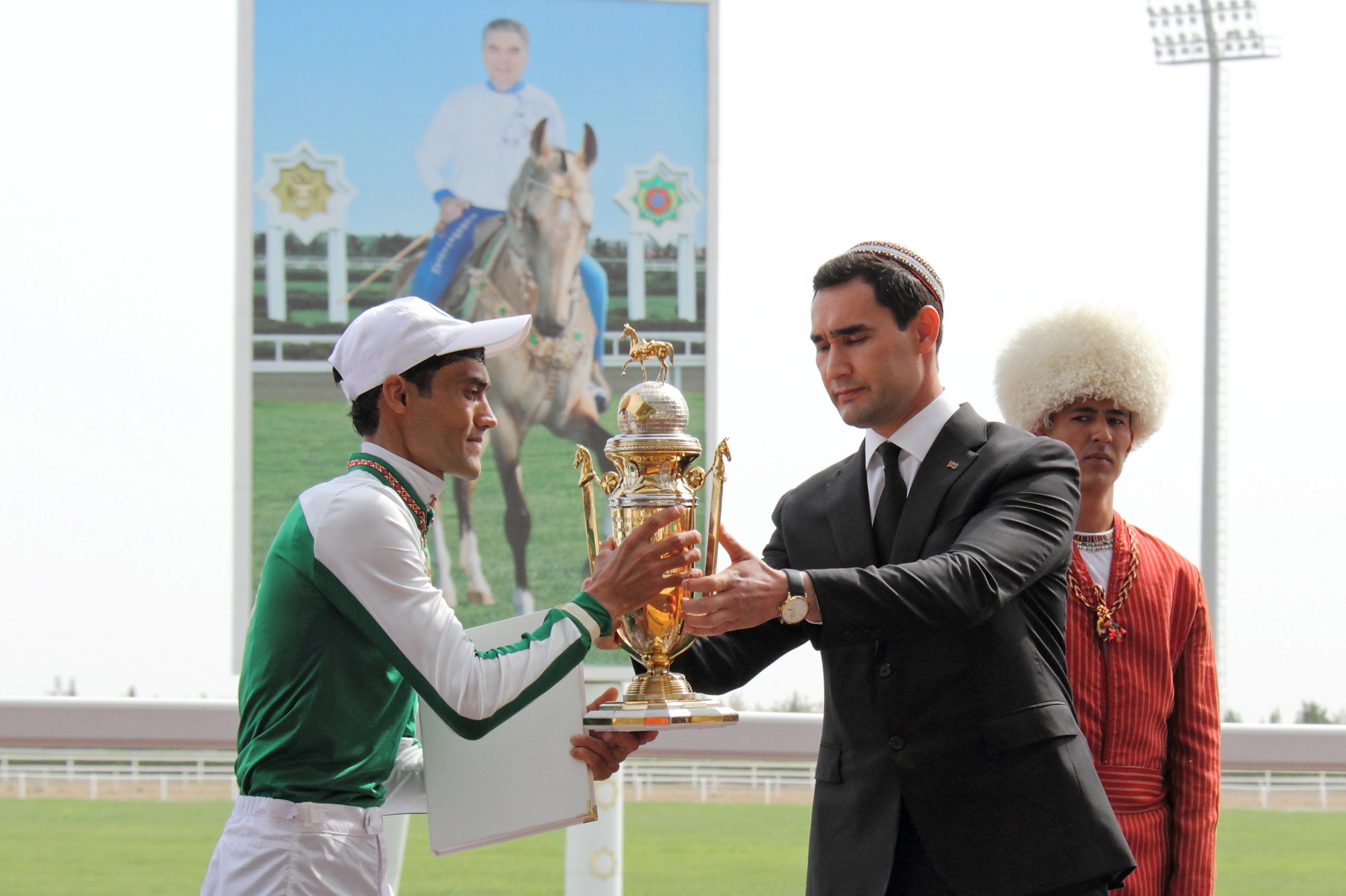 Turkmenistan's Deputy Prime Minister Serdar Berdymukhamedov, son of President Kurbanguly Berdymukhamedov, presents a trophy to a jockey during celebrations for the national Turkmen Horse Day and the Turkmen Shepherd Dog Day, near Ashgabat, Turkmenistan.