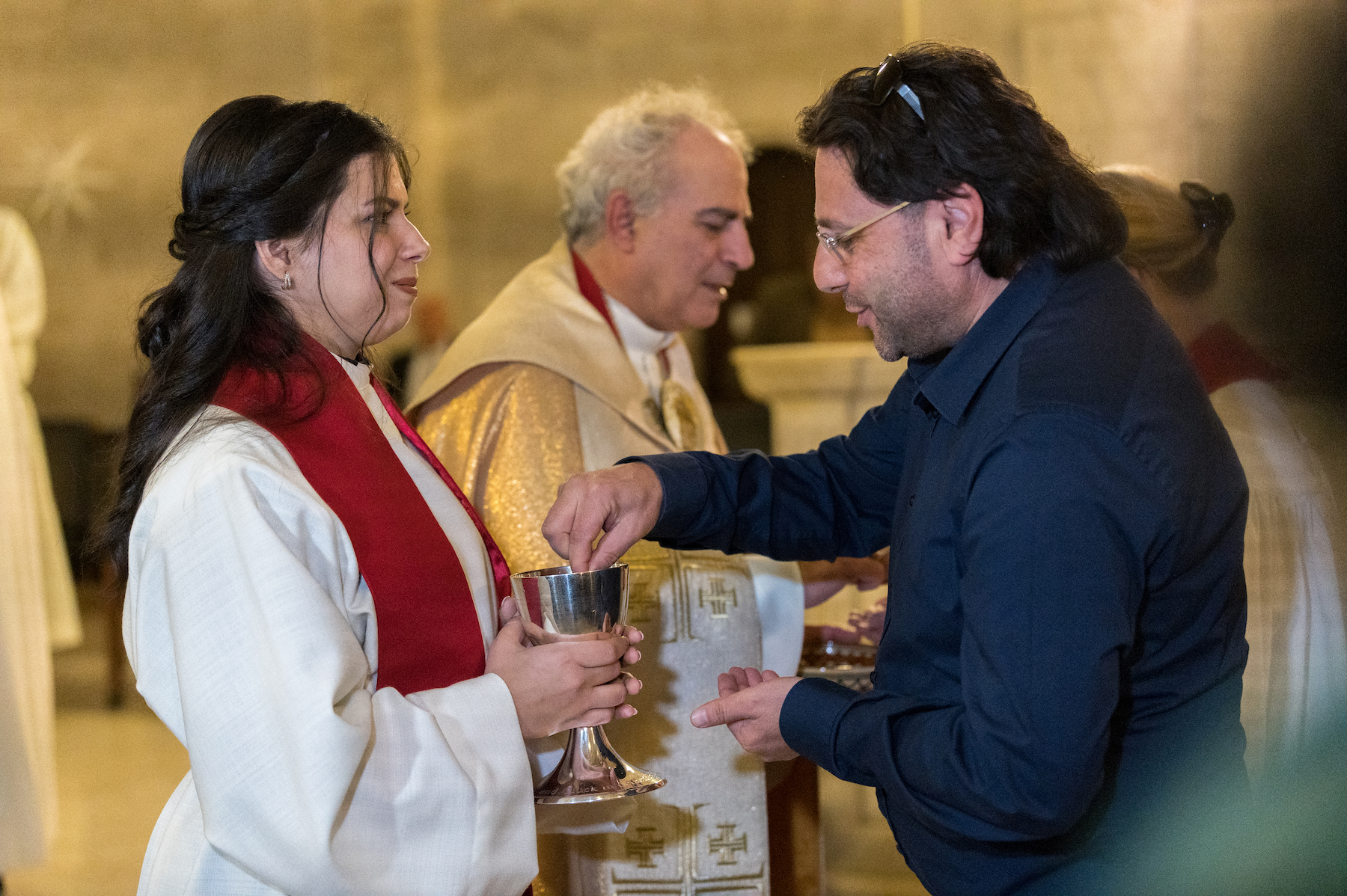 pastor sally azar holding a holy cup at her communion ceremony