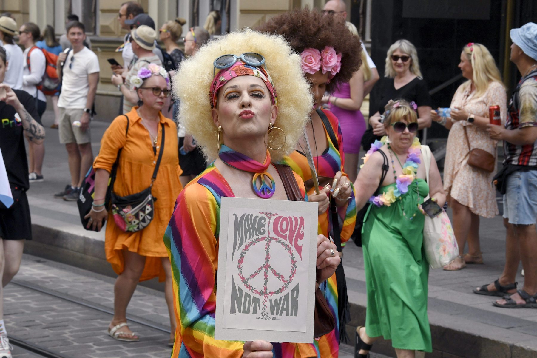 people carrying sign and doing kissing face in front of the camera
