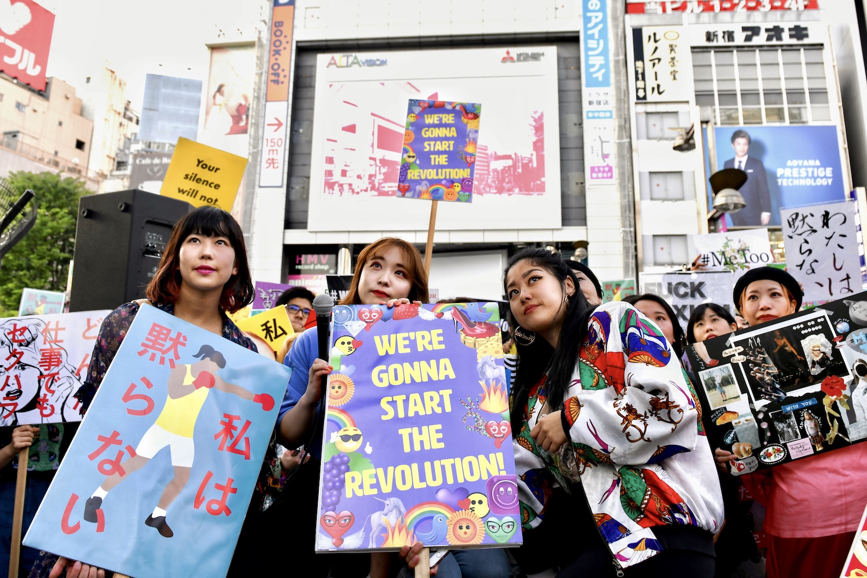 Demonstrators hold signs during a rally against sexual harassment in Shinjuku, Tokyo