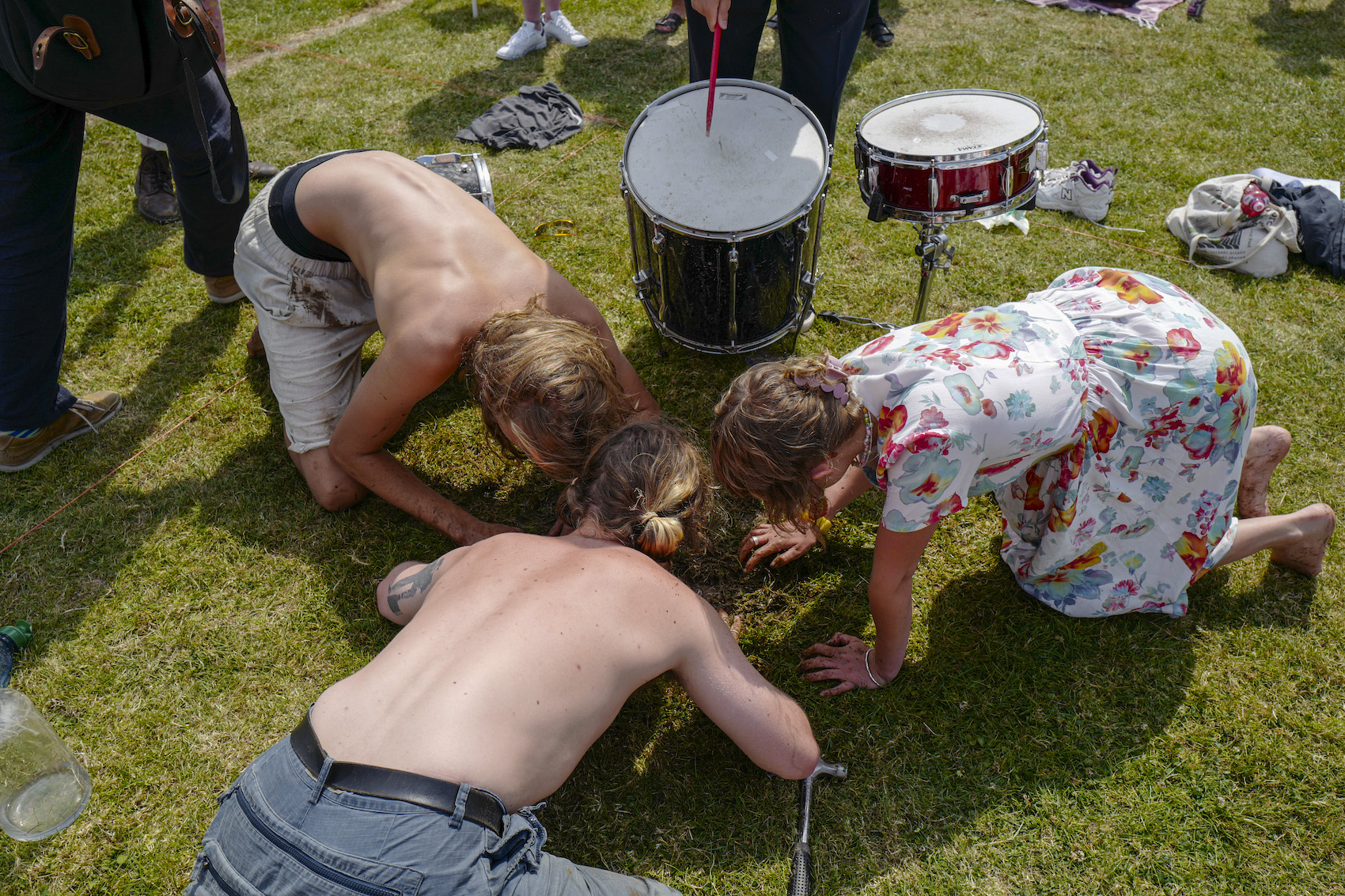 3 competitors as a group facing down to the soil attracting worms out