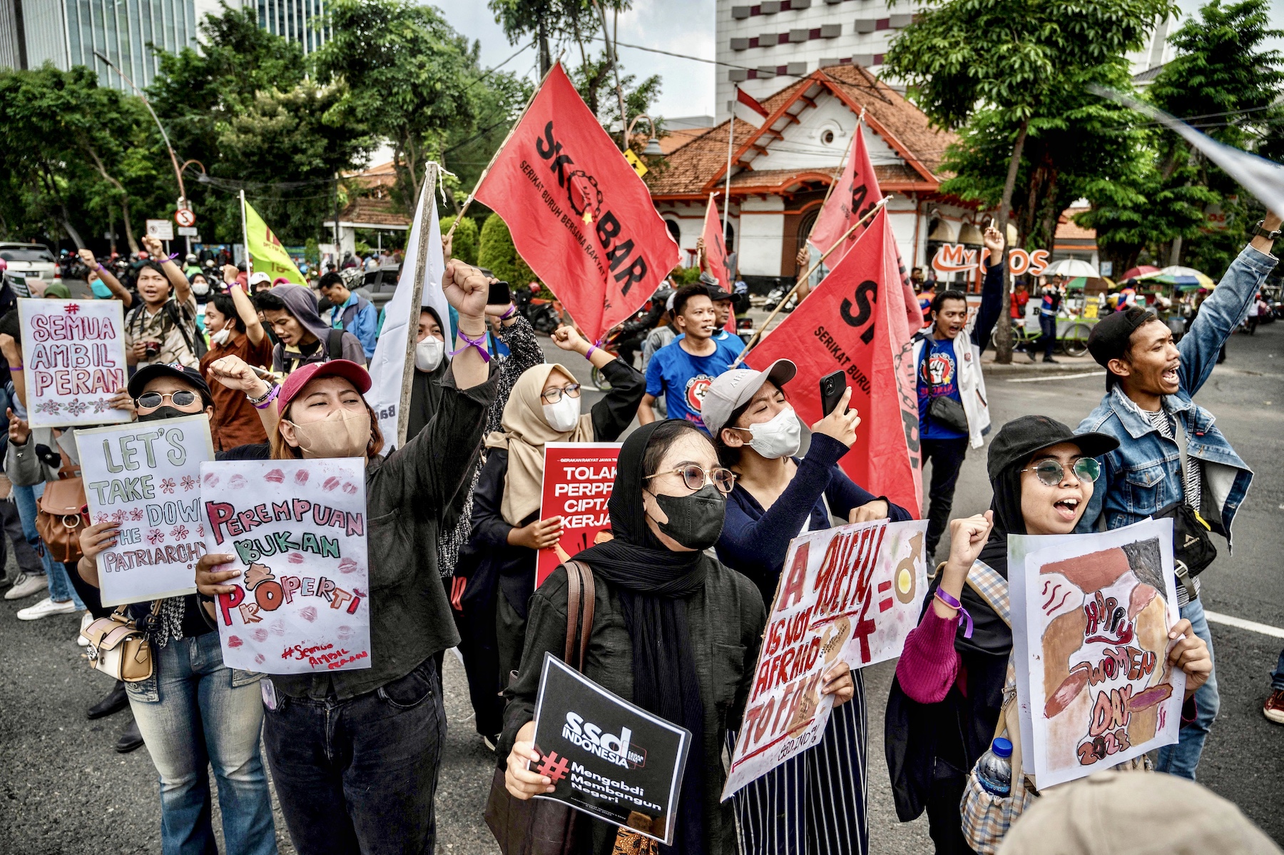 Women in Indonesia hold signs and march for International Women's Day