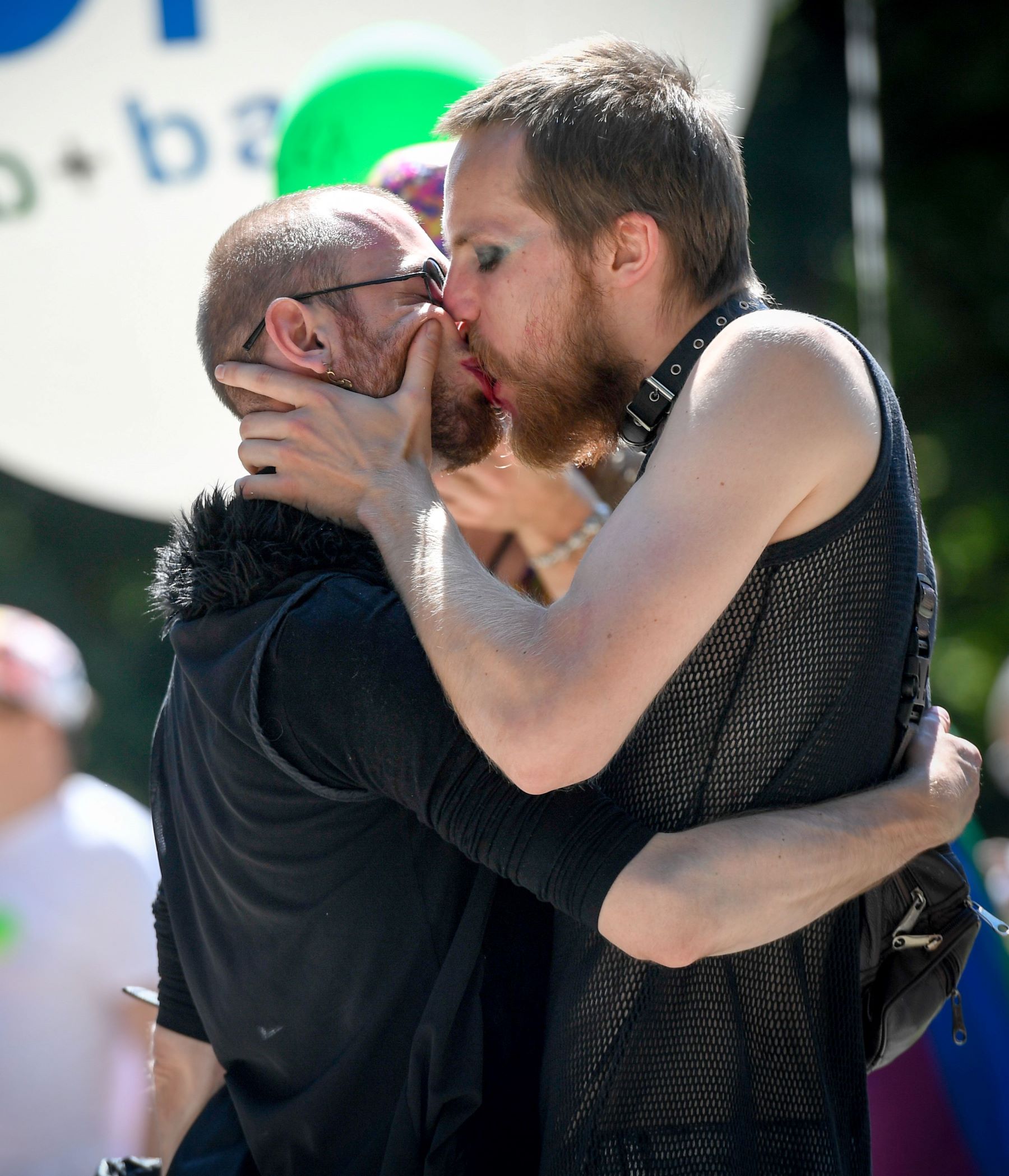 Two men kiss each other