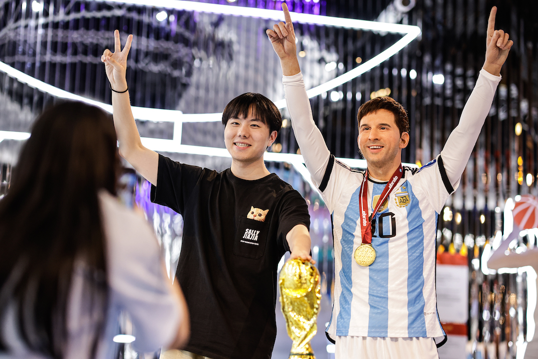 Chinese fan takes a picture in front of Lionel Messi's wax figure