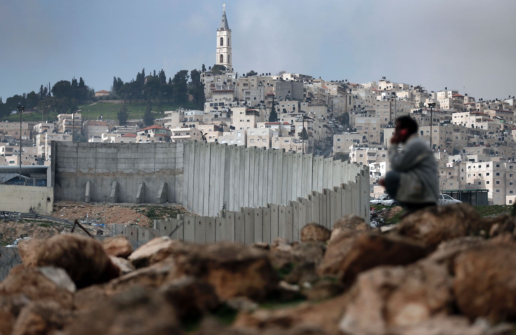 man sits near Israel controversial separation barrier