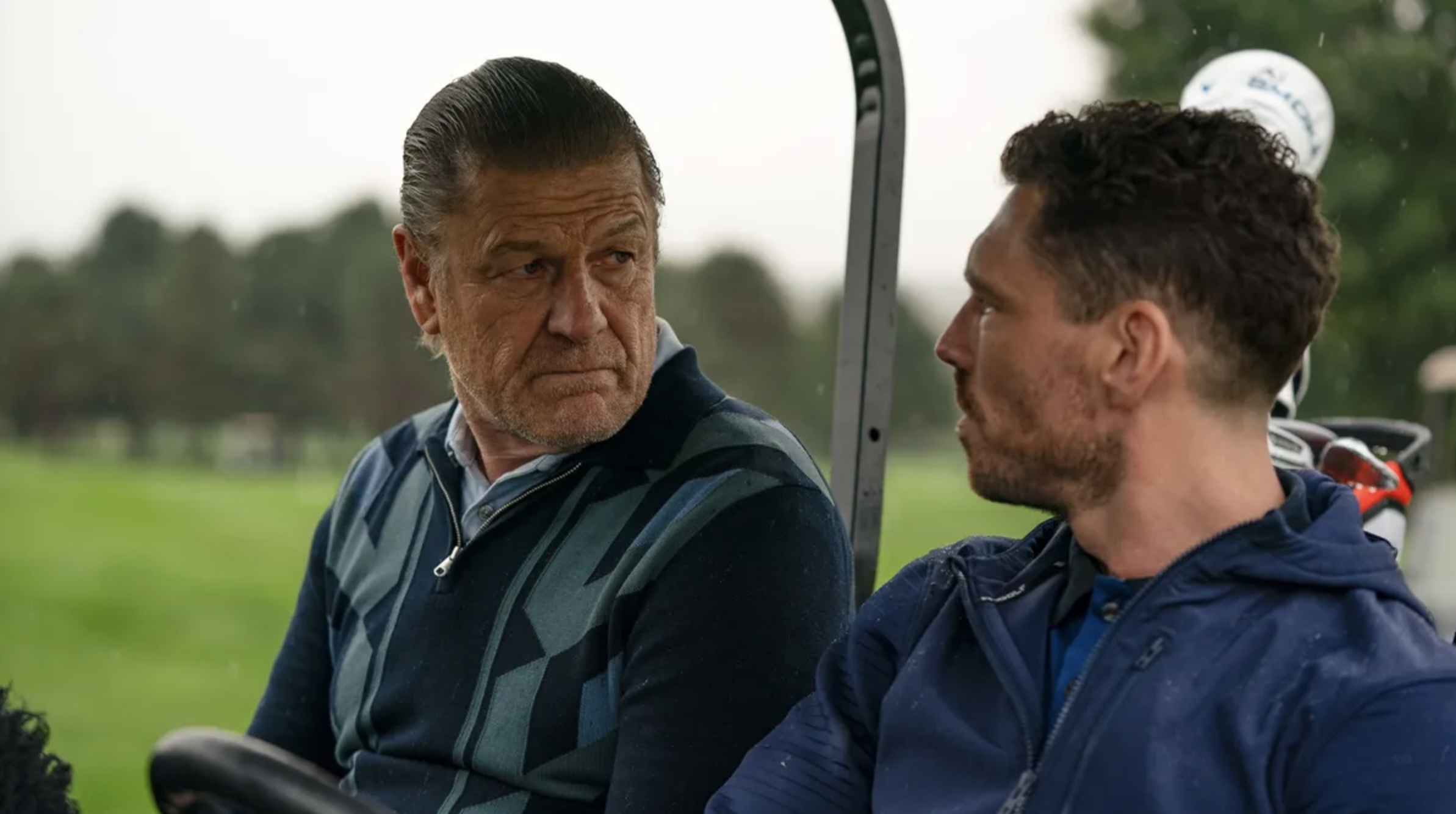 Ronnie Phelan (Sean Bean) and Michael  (James Nelson-Joyce) discuss the business in a golf cart