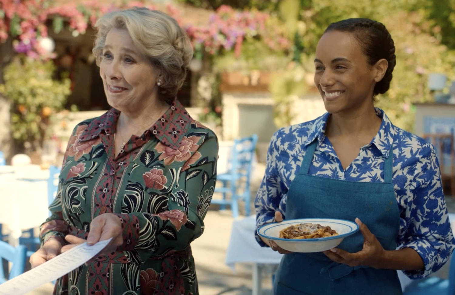 Elena (Phyllis Logan) holds a menu and Daria Solistano (Gaia Scodellaro) offers a dish of Joe's ragu