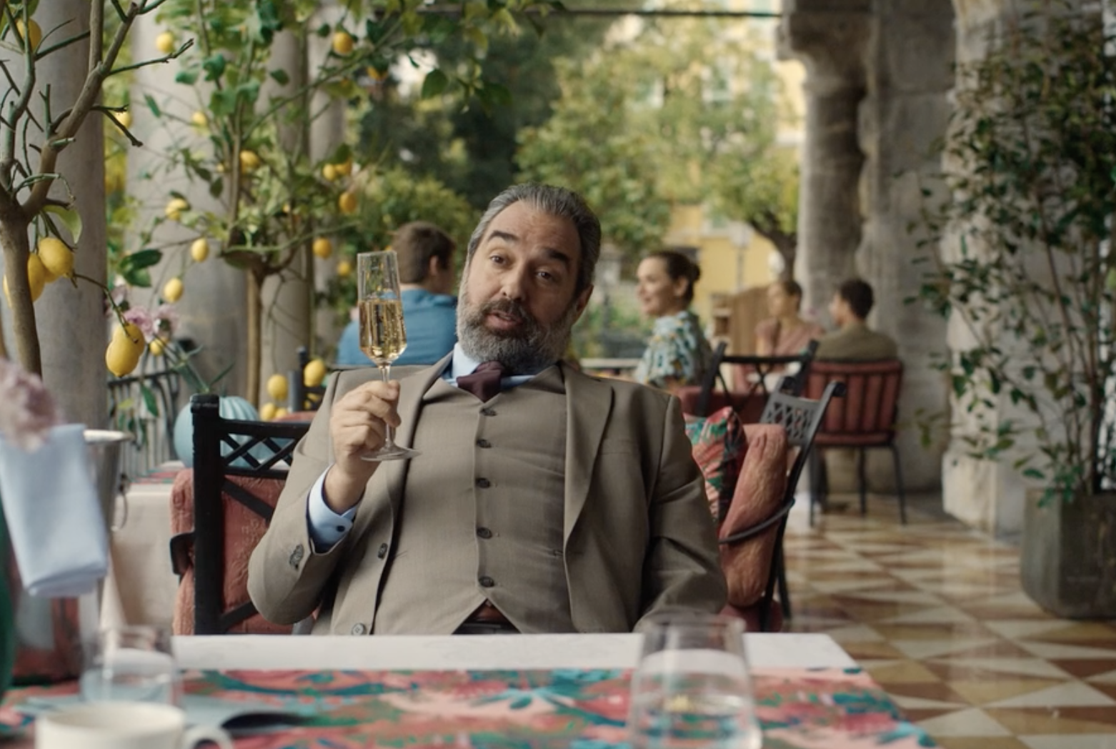 Seated on a terrace surrounded by lemon trees, Dr. Mitrea raises his glass to his old friend Valerie. 