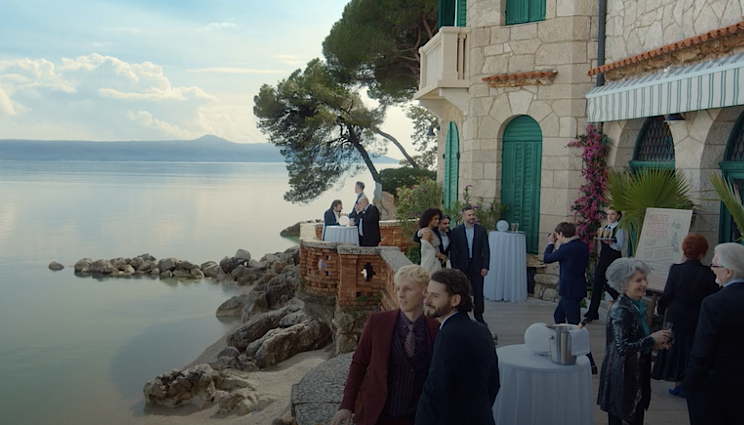 Expecting an evening of fun, guests and hosts on the villa terrace with its sea view: Max Murray (Deni Sankovic), Oscar Miller (Henry Felix), Daria Solistano (Gaia Scodellaro), Andrea Carlotti (Giuseppe Bonifati), Joe Mottram (Warren Brown) and photographer Santino Musella (Rocco Fasano).