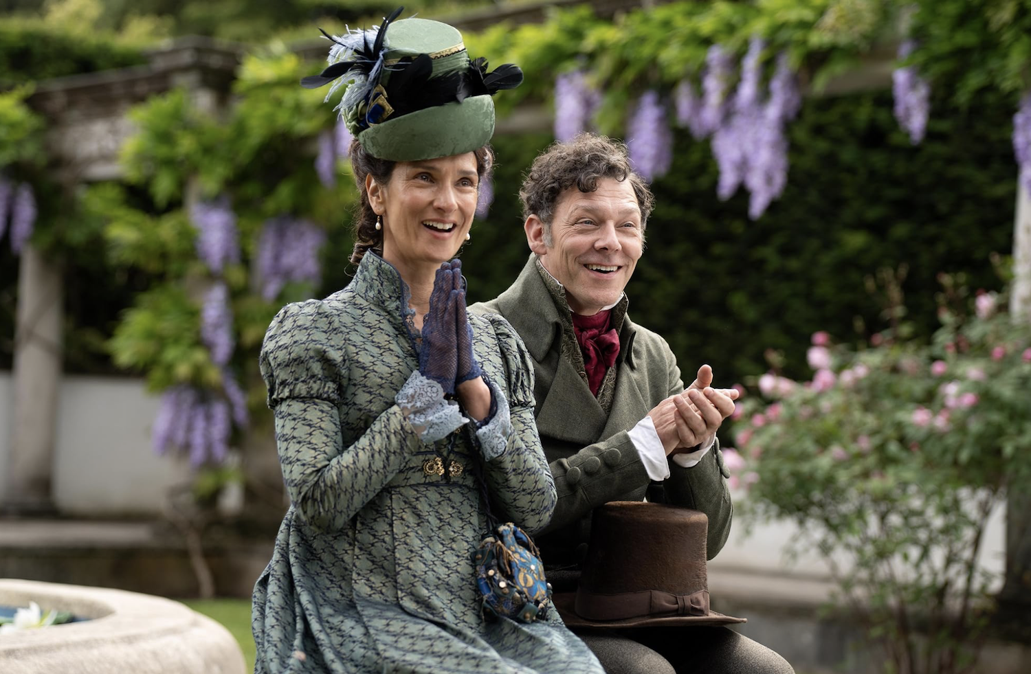 Mr. and Mrs. Gardiner (Richard Coyle and Indira Varma) in a city garden applaud as Hayward reads poetry.