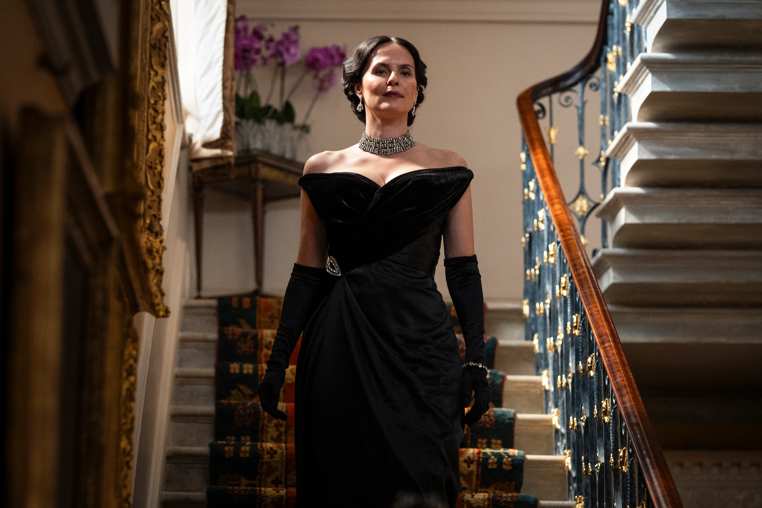Adele Fairley (Leanne Best) wearing a stunning black gown and jewelry descends the staircase to take over the party.