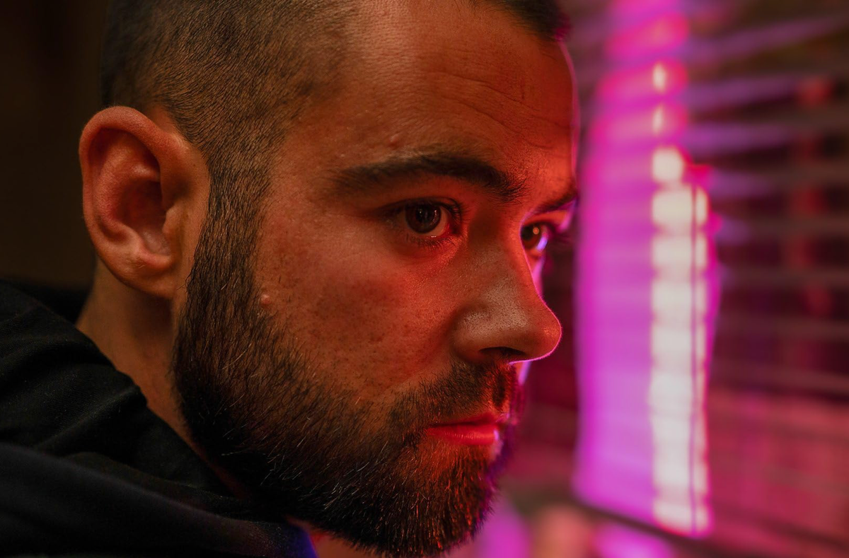 Jamie (Jack McMullen) bathed in red light at a window.