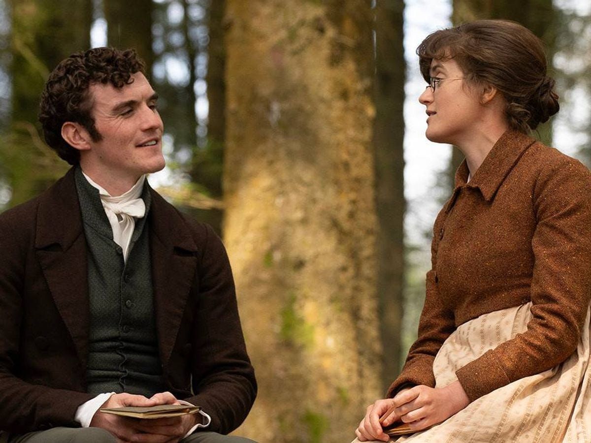 Tom Hayward (Dónal Finn) and Mary (Ella Bruccoleri) share a moment in a wooded area.