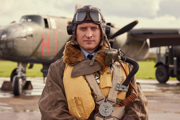James Herriot (Nicholas Ralph) in flying gear with a plane in the background.