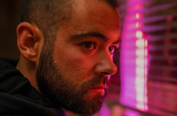 Jamie (Jack McMullen) bathed in red light at a window.