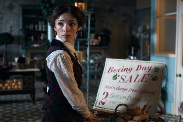 Emma Harte (Jessica Reynolds) in her grocery shop prepares for a Boxing Day sale.