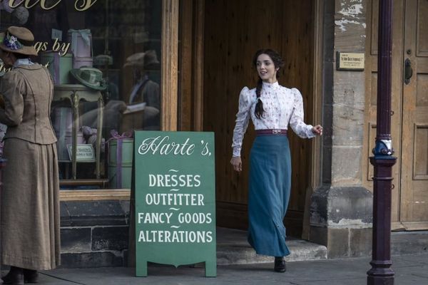 Emma Harte (Jessica Reynolds) steps outside her new shop.