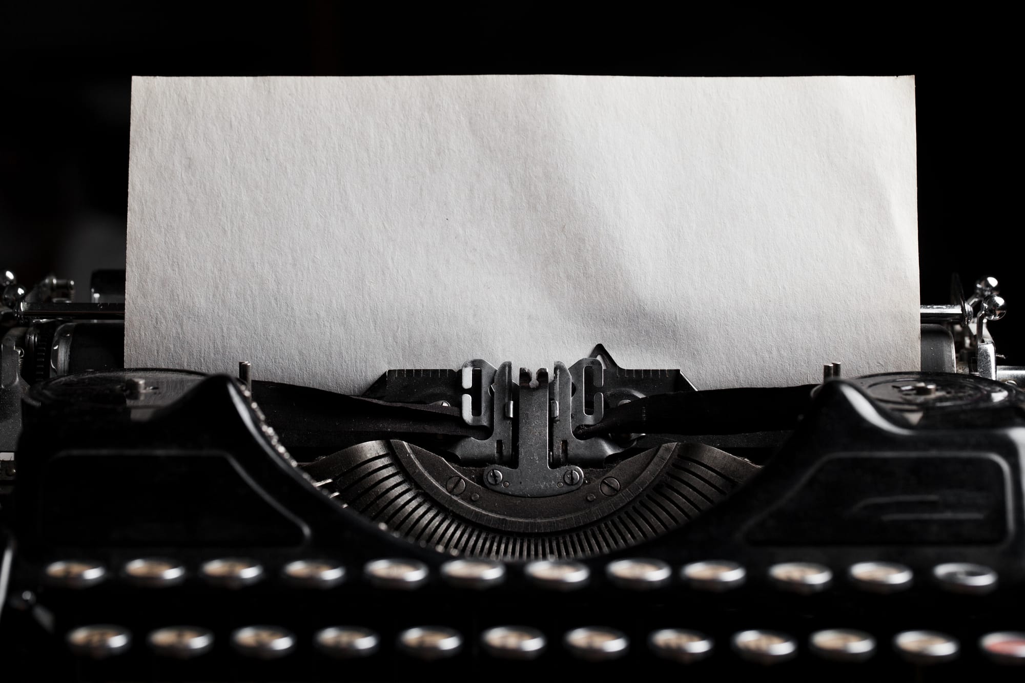 Close-up of a blinking text cursor on a blank white screen, symbolizing creative doubt and procrastination.