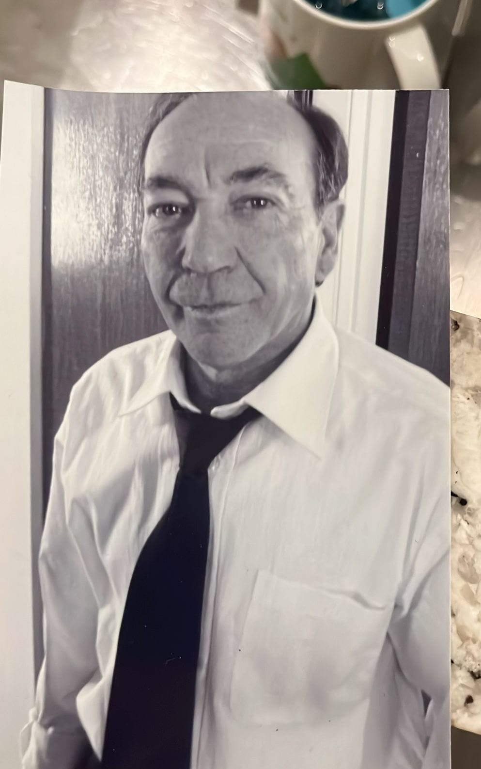 A black and white portrait of the author's father, a man with a kind expression.