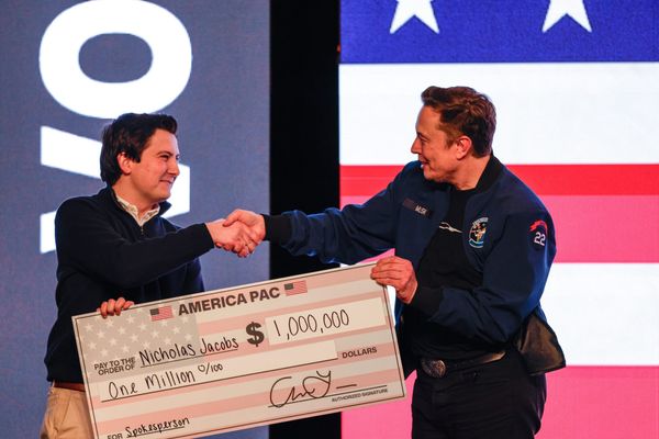 Elon Musk handing a large check for $1 million to a voter in Green Bay.